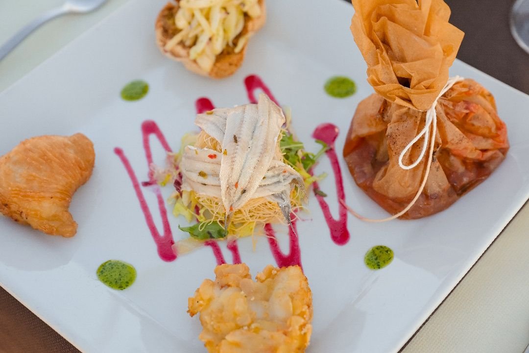 Antipasto misto: alici marinate su insalatina, fagottino di pasta fillo e fritti con salse colorate
